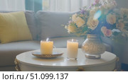 A warm and inviting living area features candles and fresh flowers enhancing the ambiance. Стоковое AI-видео, аниматор Данила Большаков / Фотобанк Лори