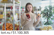 Young woman choosing soy sauce in grocery. Стоковое видео, видеограф Яков Филимонов / Фотобанк Лори