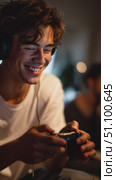 Enjoying gaming moments at night with friends in a cozy setting while wearing headphones and focused gameplay. Стоковое AI-видео, аниматор Сергей Толмачёв / Фотобанк Лори