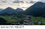Sun setting behind mountains illuminating Wiesing village in Tyrol, Austria. Стоковое фото, фотограф Данил Руденко / Фотобанк Лори
