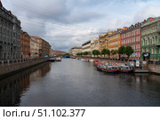 Saint Petersburg, Russia, July 21, 2024: View of the historical residential buildings on the Moika River embankment and the Blue Bridge. Редакционное фото, фотограф Ula Ulachka / Фотобанк Лори