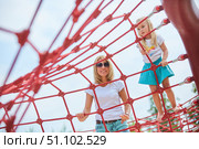 A girl with her mother climbs a rope attraction in the park. Entertainment for children. Стоковое фото, фотограф Наталия Кирсанова / Фотобанк Лори