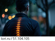 Man walking away showing glowing spine and vertebrae. Стоковое AI-изображение, AI-художник Иван Рябоконь / Фотобанк Лори