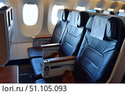 Empty seats in the cabin of a modern passenger airplane showing comfort and space. Стоковое AI-изображение, AI-художник Иван Рябоконь / Фотобанк Лори