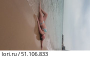 A 50-year-old European woman in a swimsuit walks along the beach in Doha, Qatar. Стоковое видео, видеограф IRYNA ZAKHARANKA / Фотобанк Лори