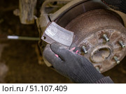 A gloved hand holds a pair of shiny new brake pads ready to be installed into a car's braking system. Стоковое фото, фотограф Коханова Наталья / Фотобанк Лори