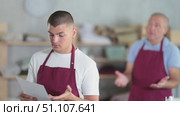 Mature tailor scolds the assistant and fires him. Young upset tailor stands with his resignation papers. Стоковое видео, видеограф Яков Филимонов / Фотобанк Лори