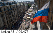 Российский флаг над улицей города в Европе. Russian flag over a city street in Europe. Стоковое AI-изображение, AI-художник Смирнова Светлана / Фотобанк Лори