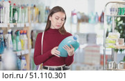 Female buyer chooses a high-quality fabric softener in the household section of a supermarket. Стоковое видео, видеограф Яков Филимонов / Фотобанк Лори