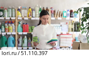 Customer in a European supermarket chooses kitchen cleaning accessories. Стоковое видео, видеограф Яков Филимонов / Фотобанк Лори