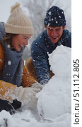 Couple enjoys winter day building snowman outside in colorful jackets and warm hats without any worries. Стоковое AI-видео, аниматор Сергей Толмачёв / Фотобанк Лори