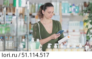 Selective middle-aged woman customer scanning QR on cream held in hand in chemistry. Стоковое видео, видеограф Яков Филимонов / Фотобанк Лори