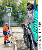 A man in a blue and orange shirt is shoveling the ground. Russia. Moscow. 19.08.25. Редакционное фото, фотограф Ярославский Максим / Фотобанк Лори
