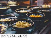 Featuring a colorful assortment of cheeses and chopped fruits elegantly displayed in bowls on a buffet table, offering guests a tempting selection for dining enjoyment. Стоковое фото, фотограф Ольга Ильина / Фотобанк Лори