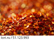 Pile of dried crushed red pepper flakes forming a small mound. Стоковое AI-изображение, AI-художник Иван Рябоконь / Фотобанк Лори