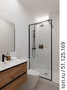 Modern bathroom with a glass shower, wooden vanity, and minimalist decor. Neutral colors create a clean and spacious atmosphere. Стоковое фото, фотограф PAv / Фотобанк Лори