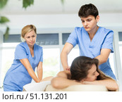 Novice masseur with female mentor performing back massage to woman. Стоковое фото, фотограф Яков Филимонов / Фотобанк Лори