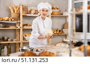 Young female baker kneading dough on table. Стоковое фото, фотограф Яков Филимонов / Фотобанк Лори