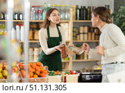Female seller offers to buy nougat to woman in interior of grocery supermarket. Стоковое фото, фотограф Яков Филимонов / Фотобанк Лори