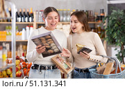 Two girls in store while shopping, choose sweets and chat sweetly. Стоковое фото, фотограф Яков Филимонов / Фотобанк Лори