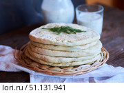 Hot Ossetian pie with cheese and herbs on the table with fermented milk national drink. Стоковое фото, фотограф Наталия Кирсанова / Фотобанк Лори