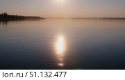 Спокойное озеро на рассвете с золотистыми бликами / Tranquil lake at sunrise with gentle water ripples and golden light. Стоковое AI-видео, аниматор DeFusum / Фотобанк Лори