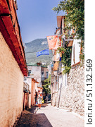 Gurzuf, Crimea, 6 July 2020, People walk along narrow urban street in small town. Редакционное фото, фотограф Spirit River / Фотобанк Лори