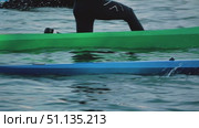 Girls paddling a kayak and canoe glide across the watery glaze of a lake. The scene conveys the dynamics of water sports movement. Close-up, side view. Стоковое видео, видеограф Воловодов Владимир / Фотобанк Лори