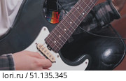 Close-up of a man skillfully playing an electric guitar in a home studio. Strings and fingerboard are in the center of attention. The guitarist is working on recording a song. Стоковое видео, видеограф Воловодов Владимир / Фотобанк Лори