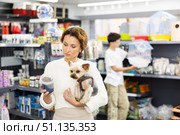 Woman selecting dry dog food for Yorkie in pet store. Стоковое фото, фотограф Яков Филимонов / Фотобанк Лори