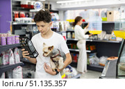 Preteen boy selecting dry dog food for Yorkie in pet store. Стоковое фото, фотограф Яков Филимонов / Фотобанк Лори