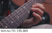 Close-up of electric guitar fingerboard with clearly outlined fret and hand of musician playing solo. Guitarist in home studio. Slow motion. Стоковое видео, видеограф Воловодов Владимир / Фотобанк Лори