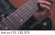A close-up of a guitarist's hand pressing the strings of an electric guitar shows detailed finger placement. Slow motion of a guitar playing. Стоковое видео, видеограф Воловодов Владимир / Фотобанк Лори