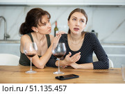 Sad woman sits silently in kitchen, friend sympathize and comfort her. Стоковое фото, фотограф Яков Филимонов / Фотобанк Лори