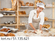 Professional female baker kneading dough in artisan bakery. Стоковое фото, фотограф Яков Филимонов / Фотобанк Лори