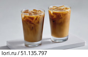 White surface presenting iced coffee glasses with transparent brown liquid, gently spinning in minimalist studio, embodying summer beverage coolness. Стоковое AI-видео, аниматор Юрий Поздников / Фотобанк Лори