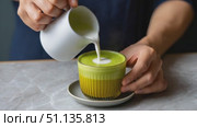 Pouring warm milk into matcha latte, creating layered texture on marble surface, showcasing artisan beverage crafting with ceramic jug. Стоковое AI-видео, аниматор Юрий Поздников / Фотобанк Лори