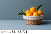Oranges in a canvas basket on a blue background. Стоковое AI-изображение, AI-художник Анна Никонорова / Фотобанк Лори