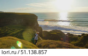 Hikers traverse a cliffside path under a beautiful sunset overlooking the ocean. Стоковое AI-видео, аниматор Данила Большаков / Фотобанк Лори