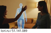 Two women communicate and gesture while engaging with a holographic figure in a cozy living space. Стоковое AI-видео, аниматор Данила Большаков / Фотобанк Лори