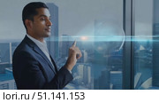 A man in a suit looks out a window at a city skyline. He gestures toward the buildings. Стоковое AI-видео, аниматор Данила Большаков / Фотобанк Лори