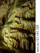 Dark cave view from inside with a lumen. Stalactites and stalagmites inside the stone grotto. Colorful stones in the cave. Lighting electricity beauty of the cave. (2019 год). Стоковое фото, фотограф Наталия Кирсанова / Фотобанк Лори
