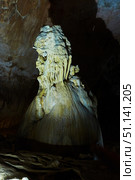Dark cave view from inside with a lumen. Stalactites and stalagmites inside the stone grotto. Colorful stones in the cave. Lighting electricity beauty of the cave. (2019 год). Стоковое фото, фотограф Наталия Кирсанова / Фотобанк Лори