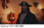 Enjoy a festive Halloween gathering featuring a pirate costume and creative pumpkin displays. Стоковое AI-видео, аниматор Данила Большаков / Фотобанк Лори