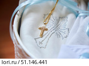 The Christian Orthodox cross lies on the baptismal clothes for the child. Christian traditions. Стоковое фото, фотограф Наталия Кирсанова / Фотобанк Лори