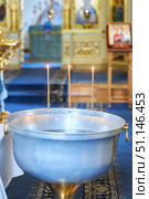 A bathhouse for the baptism of a child in Orthodoxy. Burning three candles. Christian traditions. Стоковое фото, фотограф Наталия Кирсанова / Фотобанк Лори