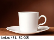 Coffee cup on wooden table in front of blurred background. Стоковое AI-изображение, AI-художник Дмитрий Нечаев / Фотобанк Лори