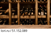 Blurred background of wine bottles in a wine store or wine shop. Стоковое AI-изображение, AI-художник Дмитрий Нечаев / Фотобанк Лори
