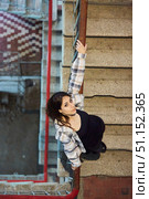 The girl is standing inside an industrial or residential building. A landing, an unkempt building. Women's clothing style is free. Стоковое фото, фотограф Наталия Кирсанова / Фотобанк Лори