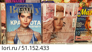 A magazine display case in a store. Three covers are clearly visible in the foreground: Cosmopolitan Beauty (winter 2018/19) with a portrait of actress Yulia Snigir, ELLE magazine (December 2018) with model Daria Strokous, and Magic and Conspiracies magazine with a bright cover promising tips on attracting wealth and amulets against negativity. The covers are made in different styles: a glossy fashion magazine with futuristic accents, a fashion publication with an airy image of a model, and an esoteric magazine with catchy headlines. The photo conveys the atmosphere of a kiosk or a printed media store, a variety of styles and content of modern periodicals. Редакционное фото, фотограф Анна Кривицкая / Фотобанк Лори
